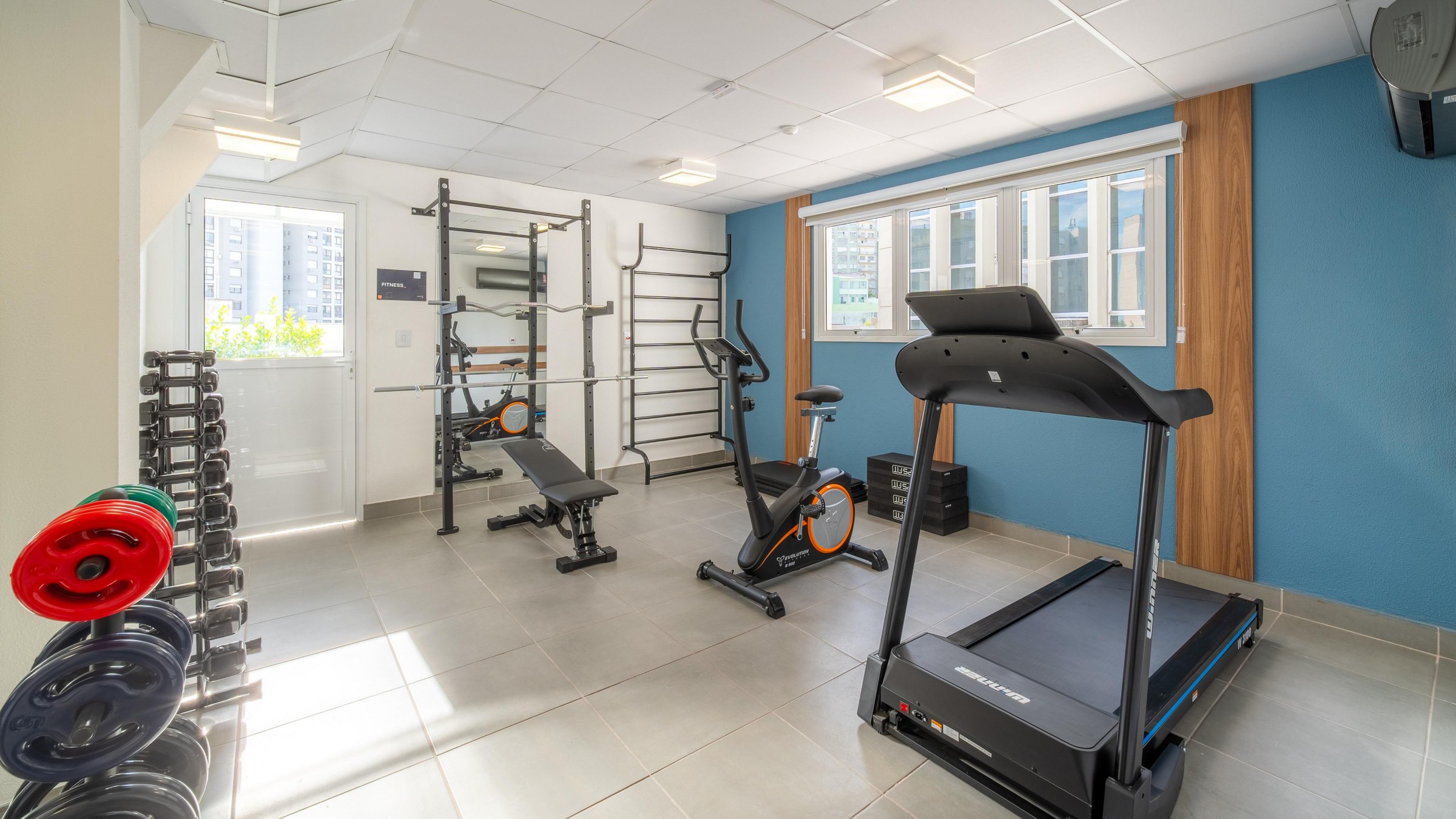 Academia com esteira, bike, halteres e estação de musculação