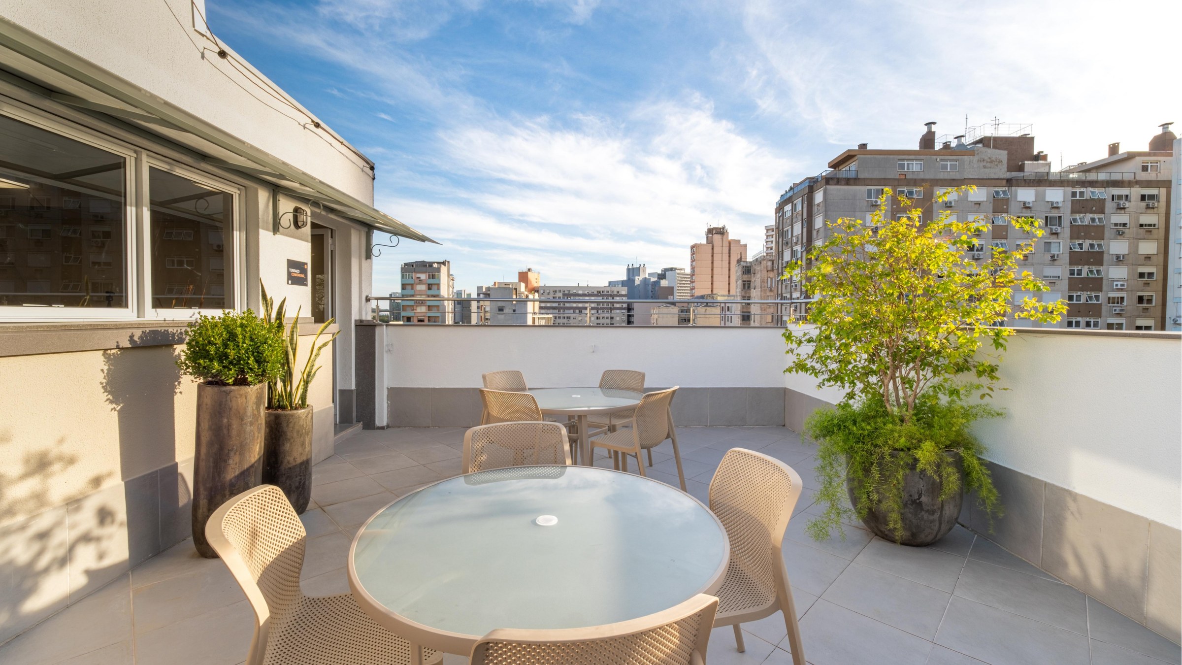 Rooftop do Genuíno 150 com lounge, plantas e vista do skyline