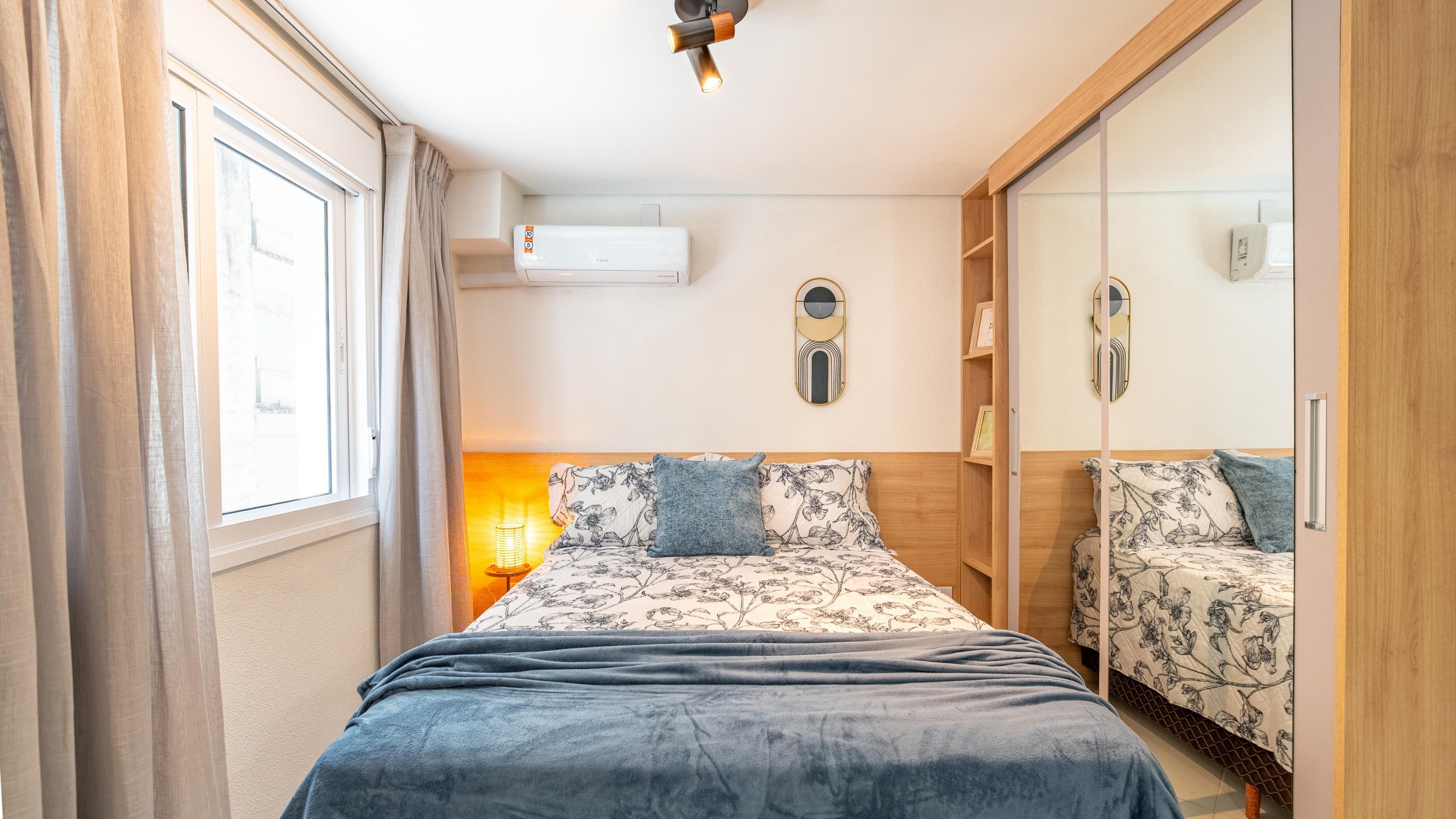 Quarto do studio decorado com cama de casal e ar-condicionado